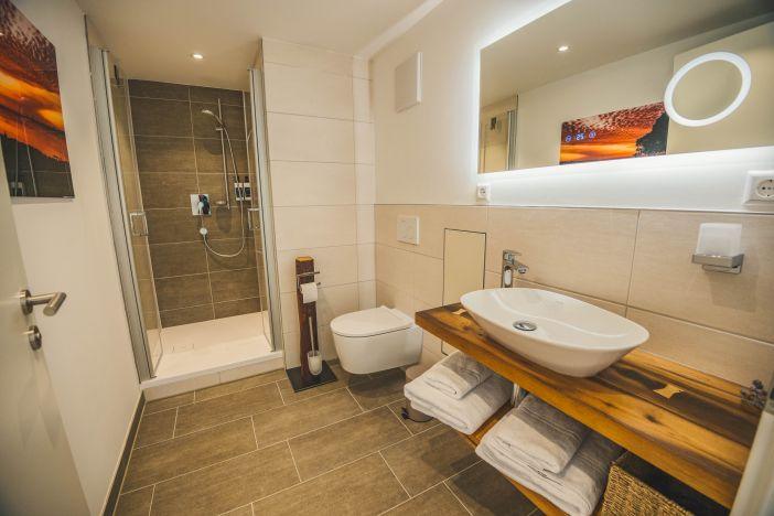 Badezimmer mit Spiegelschrank, WC und Dusche