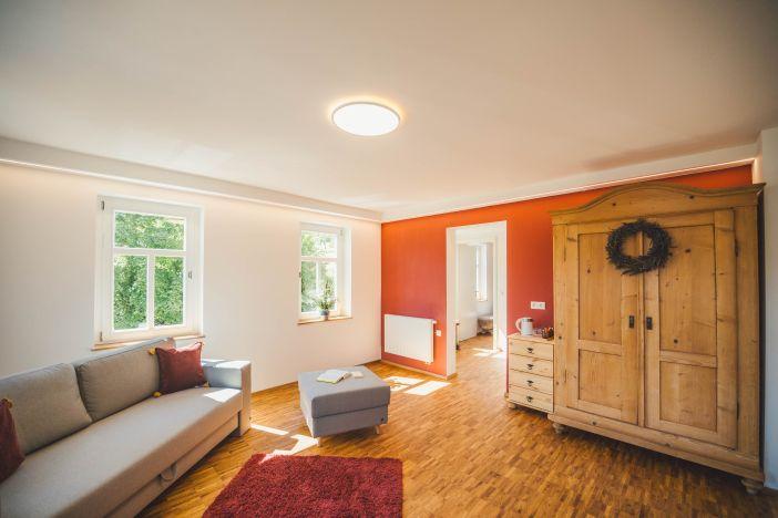 Holzschrank mit kleinem Sofa und Teppich